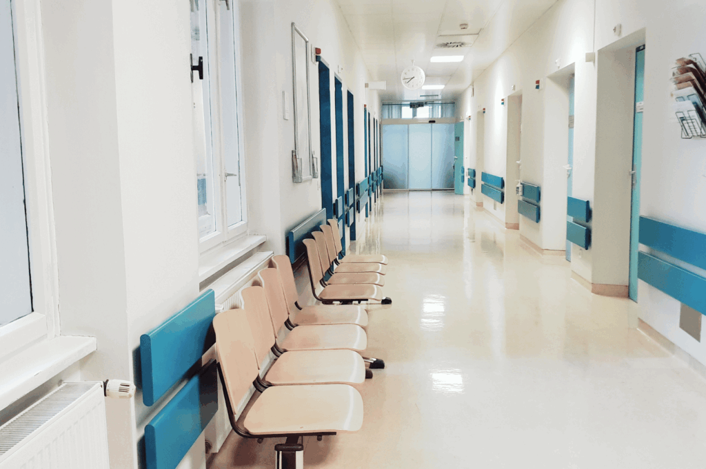 Bright, orderly hospital hallway with pastel waiting chairs, polished floors, and labeled clinic doors—illustrating Singapore’s emphasis on cleanliness, efficiency, and patient accessibility in healthcare environments.