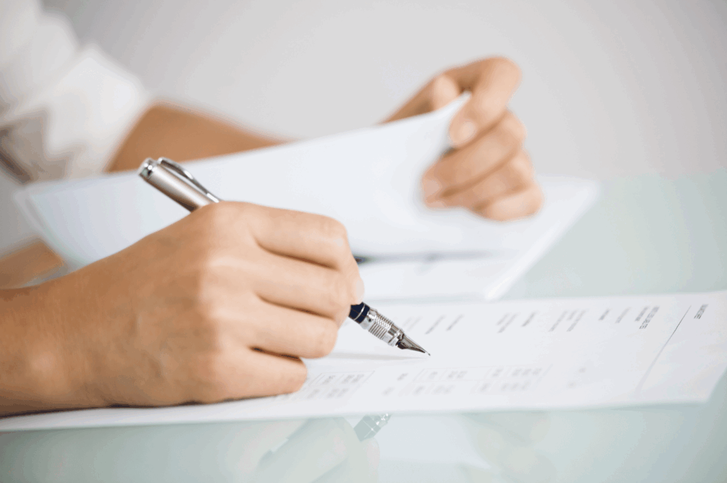 Close-up of hands reviewing printed documents and data tables on a glass surface—highlighting the analytical rigor and administrative transparency within Singapore’s healthcare system