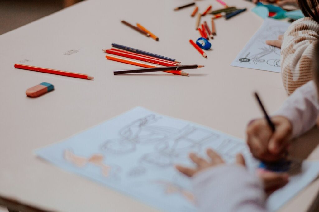 Preparing for Primary School : A nurturing classroom environment where a teacher helps a child express their feelings through drawing.