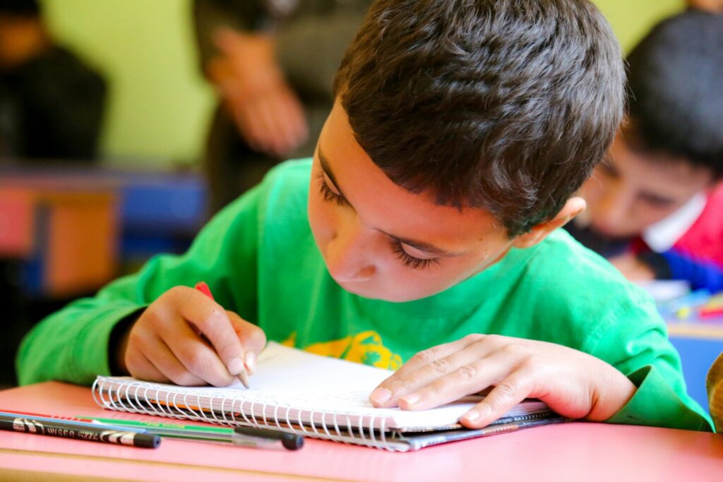 Preparing for Primary School : A teacher guiding children through a classroom activity to build learning confidence.