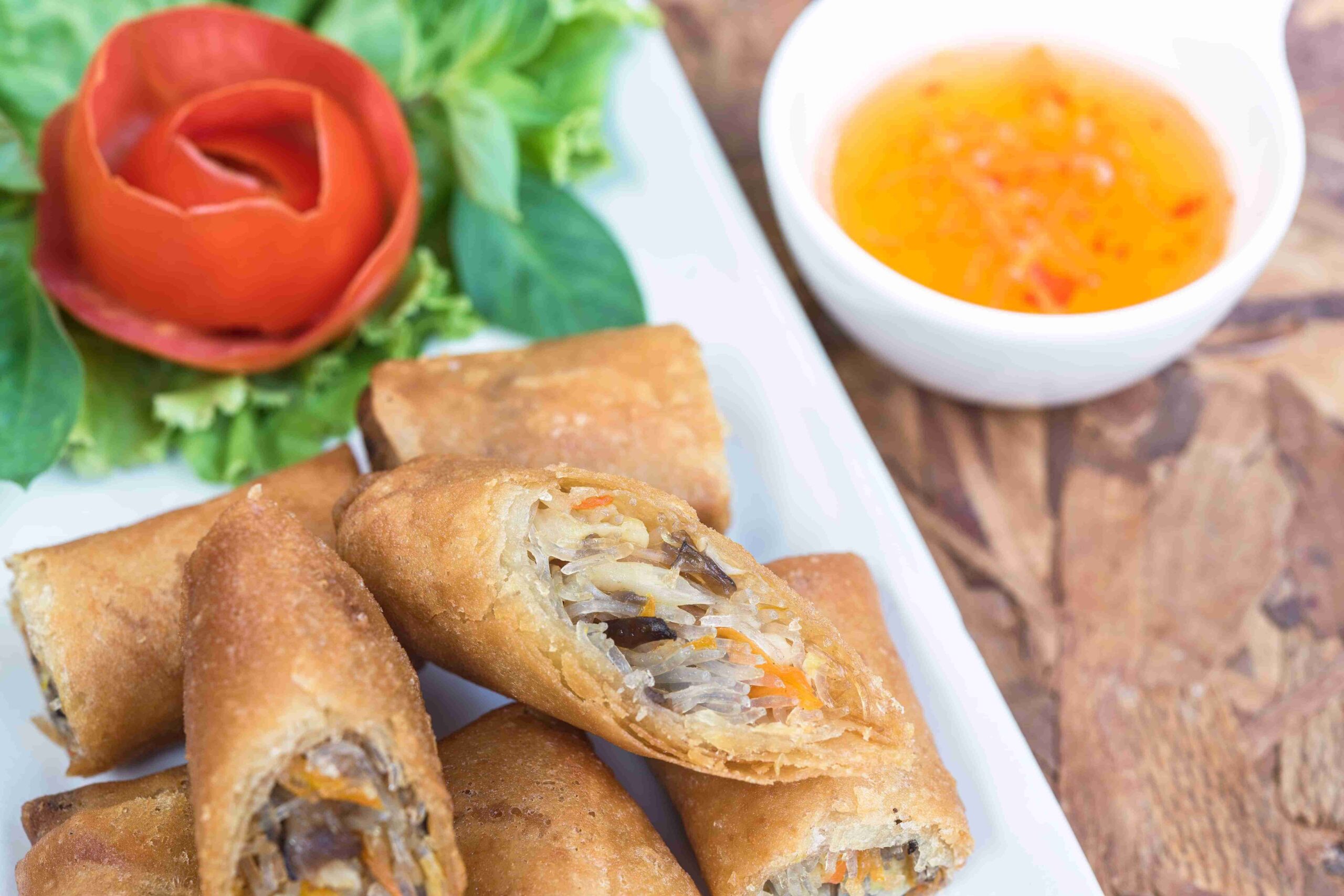 Fresh Spring Rolls aesthetically displayed with a decorative tomato skin and its sauce.