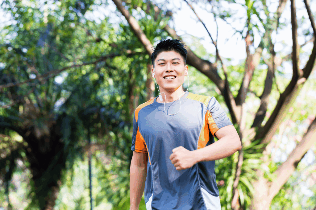 Smiling individual enjoying a morning walk in a sunlit Singapore park, embodying the joy of solo outdoor fitness in the city’s green spaces.