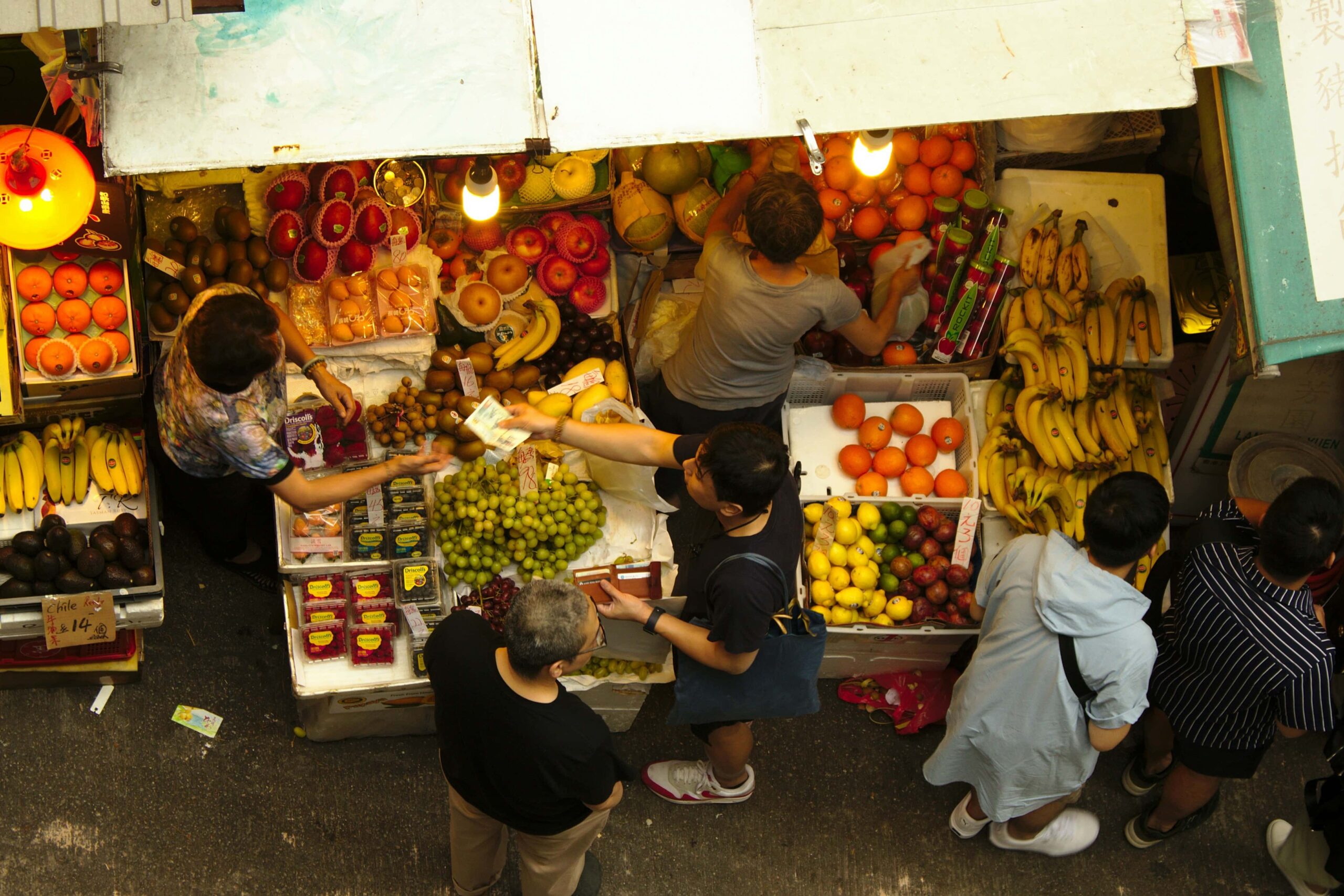 An aerial shot of people buying fresh fruits to a store in the wet market.