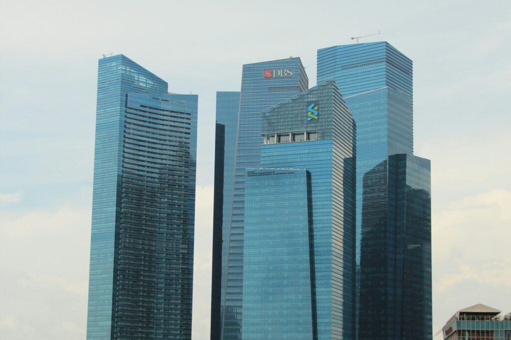Tall buildings of the Marina Bay Financial Centre in Singapore against a clear blue sky.