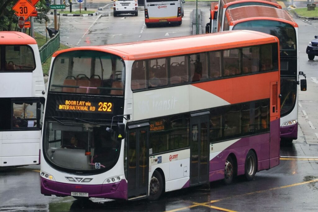 A red double-decker bus in Singapore, showcasing its iconic design and vibrant city backdrop.