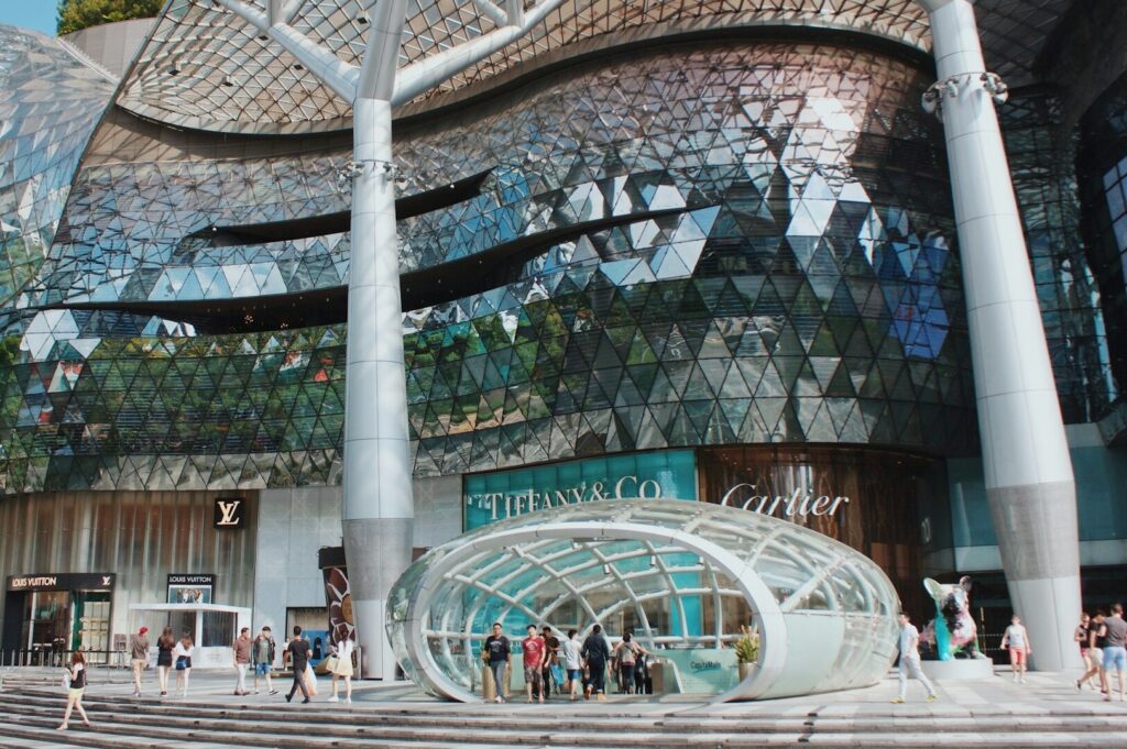 Orchard Road in Singapore, featuring a lively street scene with shops, restaurants, and urban architecture.
