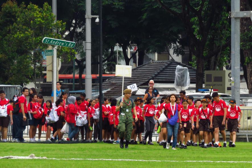 An image of students as they prepare for an assembly on the field along St. Andrew's Rd in Singapore.