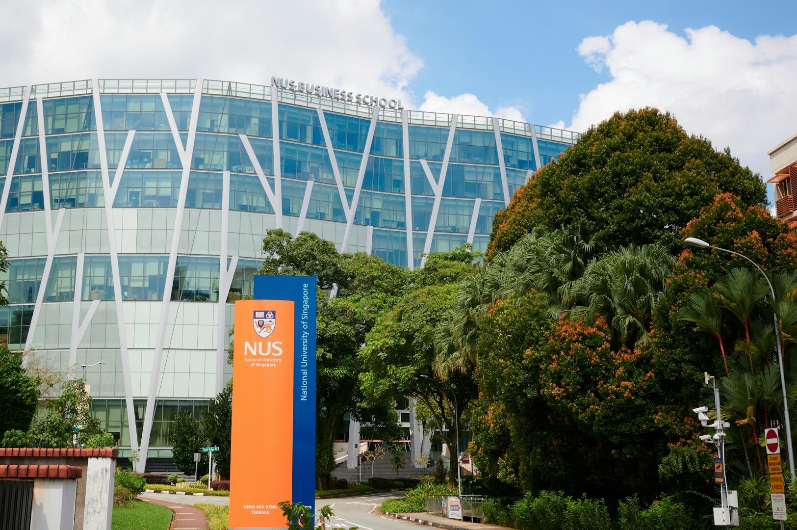A view of the University of Singapore, showcasing its contemporary buildings and vibrant campus life in a tropical setting.
