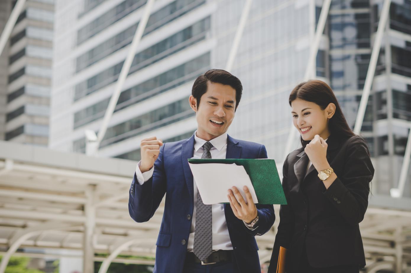 Two employees celebrating the success of their project as they look and admire their work.