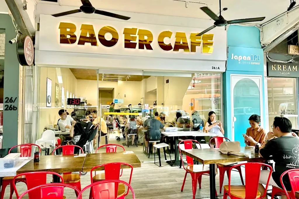 Bao Er Cafe entrance with red chairs and casual dining setup.