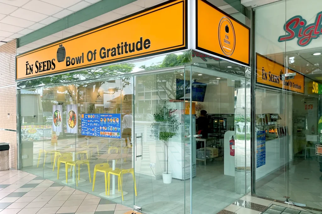 En Seeds vegetarian café with bright orange signage and glass facade.