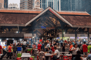 Bustling lunch rush at Lau Pa Sat hawker centre in Singapore’s central business district, showcasing open air food courts and iconic hawker stalls serving hainanese chicken rice, char kway teow, nasi lemak, chilli crab, satay, hokkien mee, and other local dishes. Expats and locals gather around food stalls and street food vendors, enjoying delicious food and exploring singapore's hawker centres like Maxwell Food Centre, Tiong Bahru Market, Airport Road Food Centre, and Satay Street. A short walk from Marina Bay, City Hall, Orchard Road, and Tanjong Pagar, this must visit spot reflects singapore's identity and hawker culture. Surrounded by international schools, mass rapid transit, and the subway system, it’s a central location ideal for expat life, moving abroad, and discovering hidden gems. With most stalls recently renovated, and other stalls offering indian food and Chinatown specialties, hawker centers offer significant impact on expat packages, school fees, health insurance, employment pass, property cost, and living tips. Anthony Bourdain once praised singapore's hawker centers as a world-class destination to eat, make new friends, and connect with your home country. This hawker center guide offers advice on navigating services, food, business, and life in Southeast Asia.
