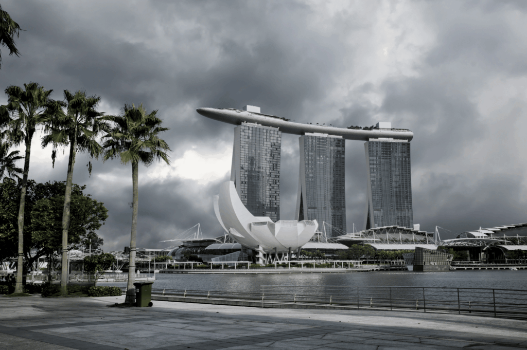 Stormy skies over Marina Bay Sands and the waterfront promenade in Singapore, hinting at incoming monsoon rain.