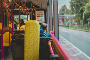 A view of passengers seated on a Singapore Bus Services bus, showcasing the interior and people engaged in various activities.