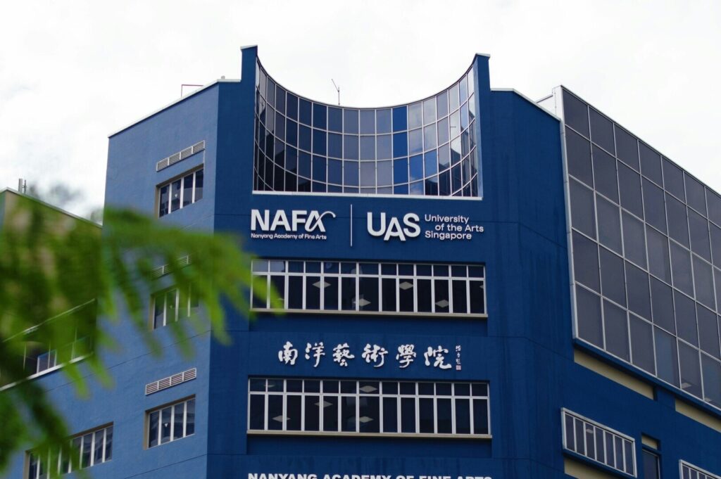 The International University in Singapore features a building with a blue facade and a sign.