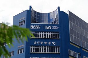 The International University in Singapore features a building with a blue facade and a sign.