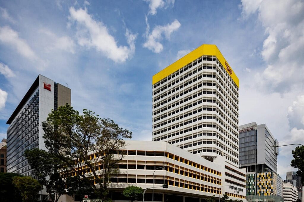 Fortune Centre Singapore, a yellow building with a striking white and yellow facade, stands out in the urban landscape.