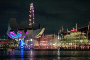 Marina Bay illuminated at night, featuring the ArtScience Museum in Singapore against a vibrant city skyline.