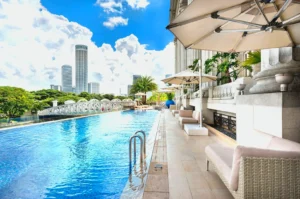 Luxury hotel pool in Singapore with skyline view and lounge seating