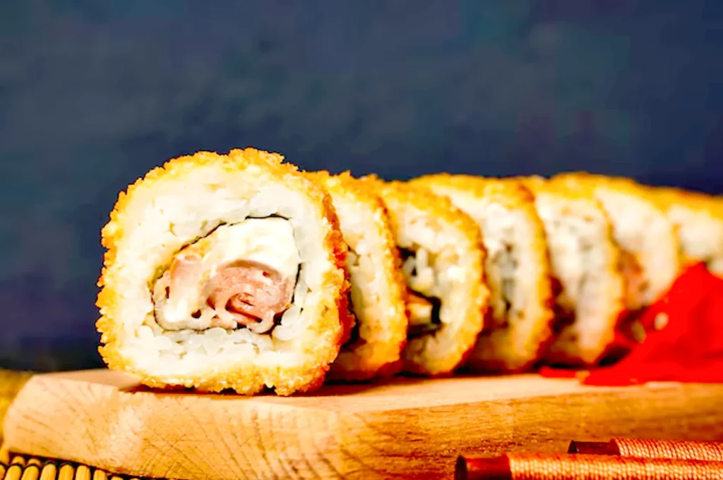 Macro close-up of crispy fried sushi rolls highlighting crunchy coating and layered filling.