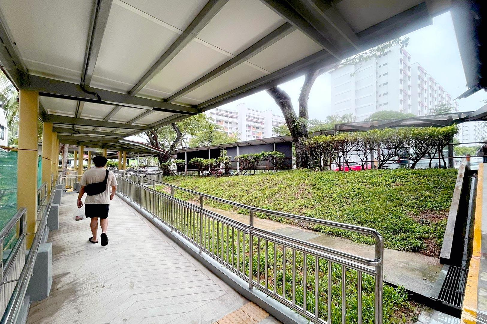 Covered walkway in Singapore residential area with pedestrian path and greenery