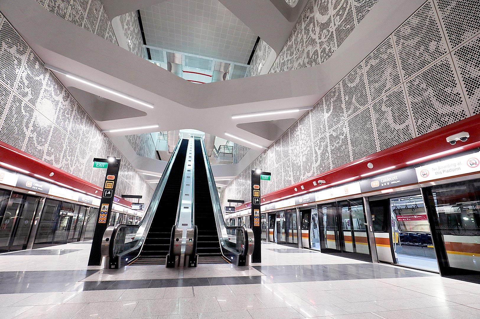 Modern Singapore MRT station interior with escalators and train platform