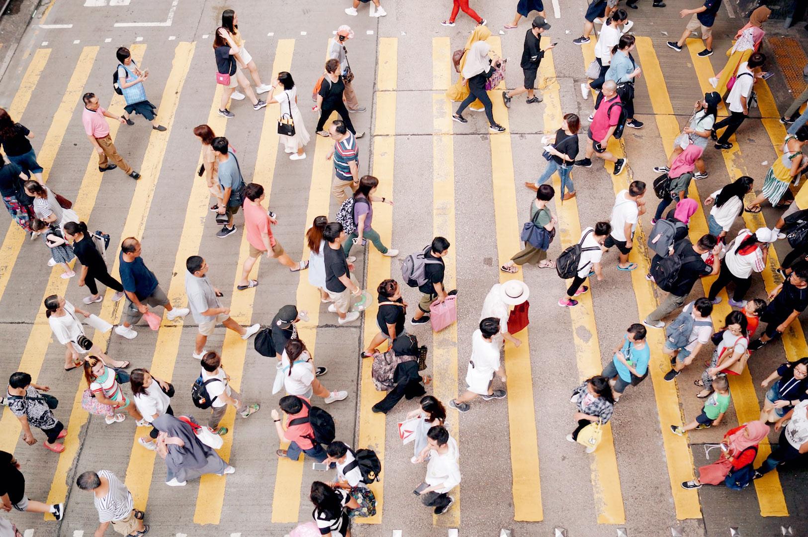 Busy pedestrian crossing in Singapore city with daily commuter crowd