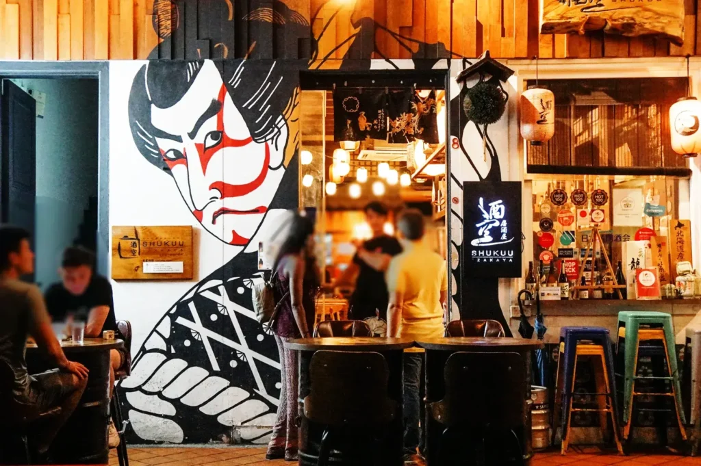 Shukuu Japanese Izakaya and Bar exterior at Telok Ayer with Japanese mural and lively evening dining crowd in CBD