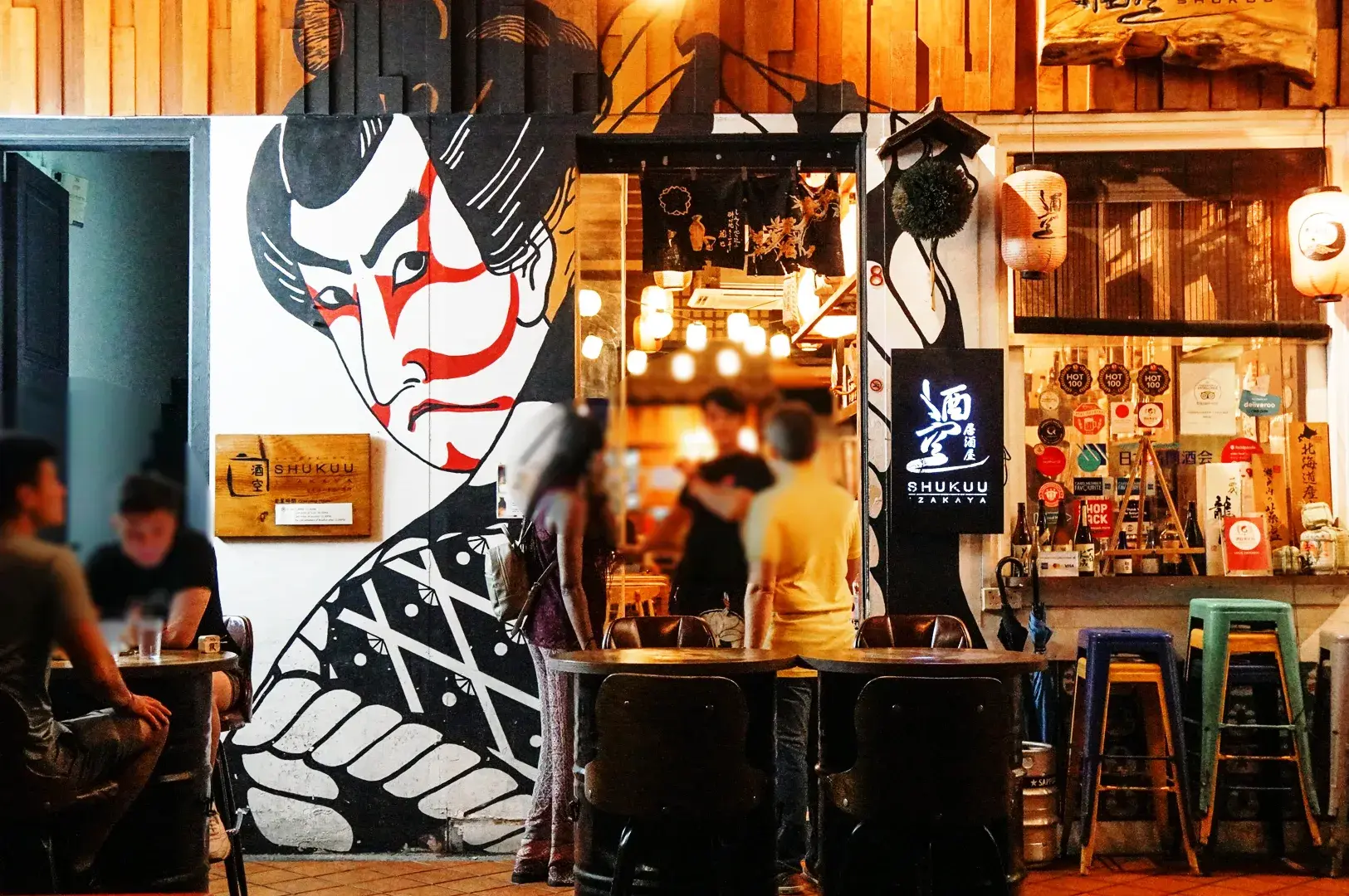 Shukuu Japanese Izakaya and Bar exterior at Telok Ayer with Japanese mural and lively evening dining crowd in CBD