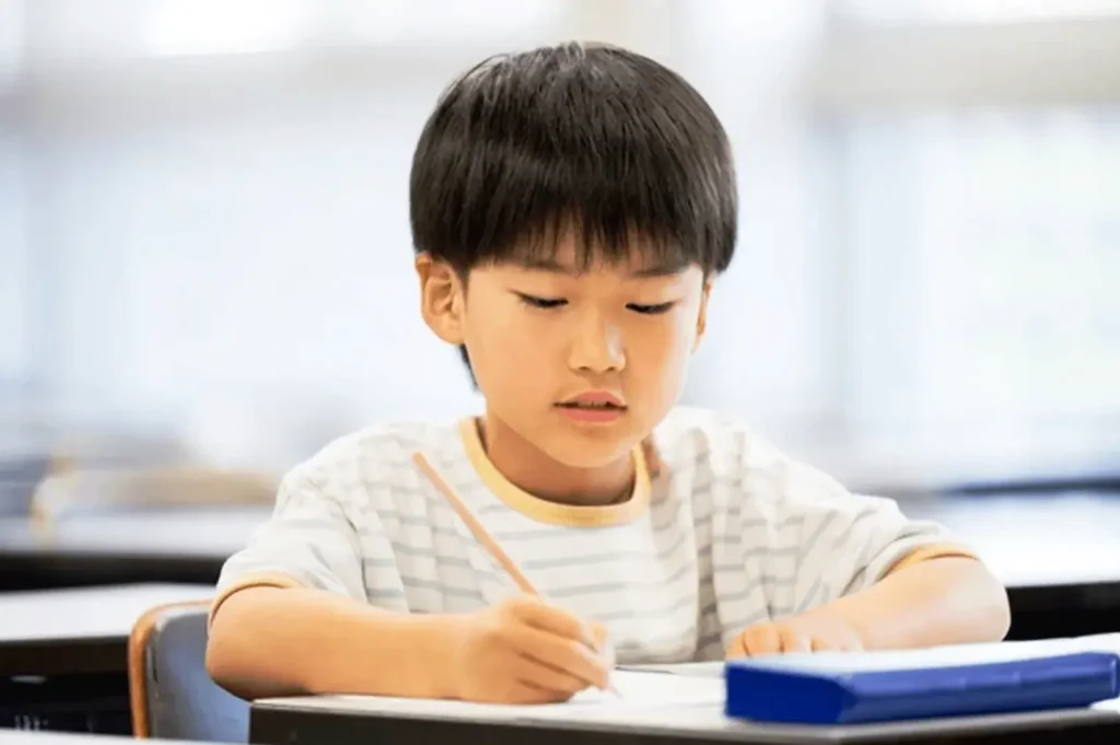 Primary school student studying for PSLE exam in Singapore classroom focused learning environment