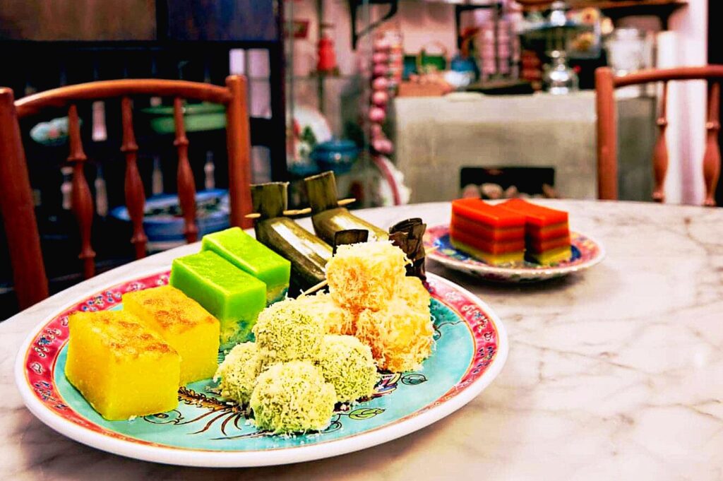 Traditional Peranakan kueh assortment in Katong Singapore with colorful desserts and heritage snacks served in local Peranakan home setting