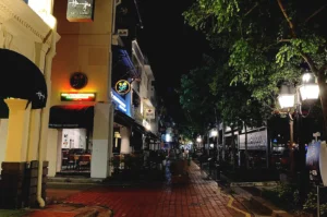 quiet Singapore street at night with warm lights and empty walkway reflecting peaceful evening walk without destination