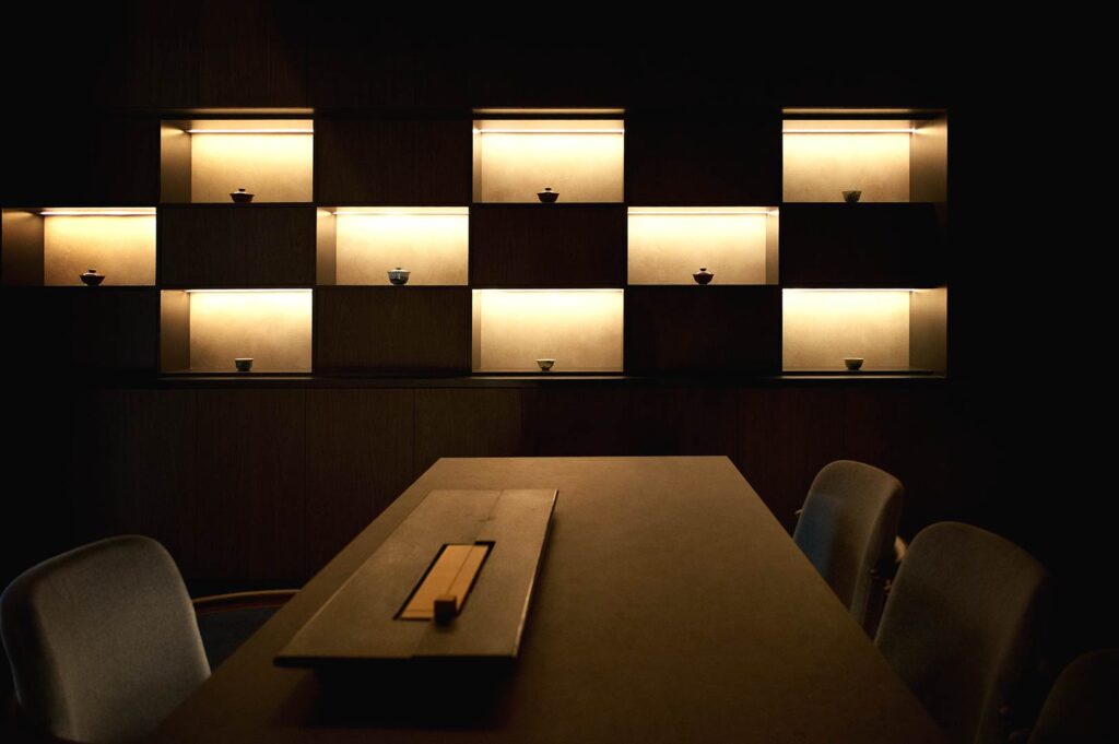 Minimalist luxury tea room interior in Singapore with softly lit shelves and curated teaware display at Tea Room by Ki-sétsu