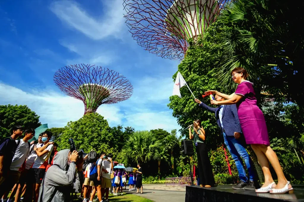 People attending outdoor public event at Gardens by the Bay in Singapore with Supertree Grove background