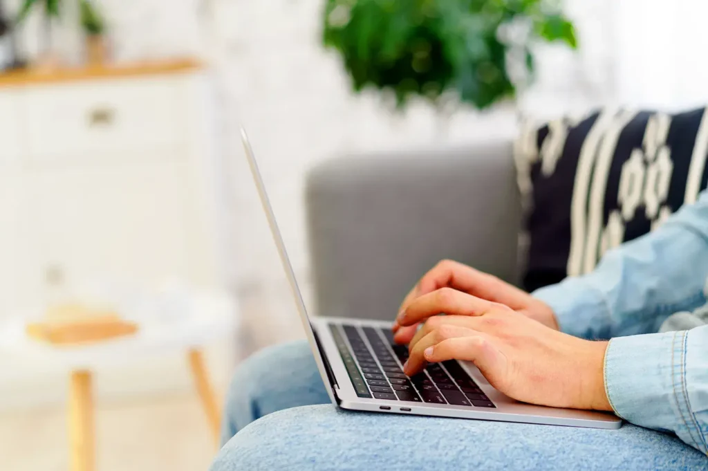 Remote worker using laptop at home in Singapore apartment for citizenship application and digital paperwork
