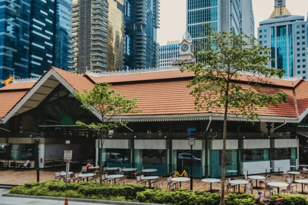A low-rise building with a terracotta tile roof sits in front of modern skyscrapers.
