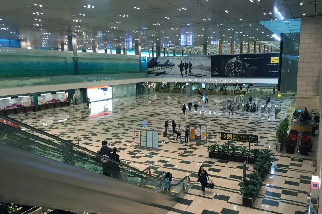 Changi Airport terminal interior with travelers and seating.