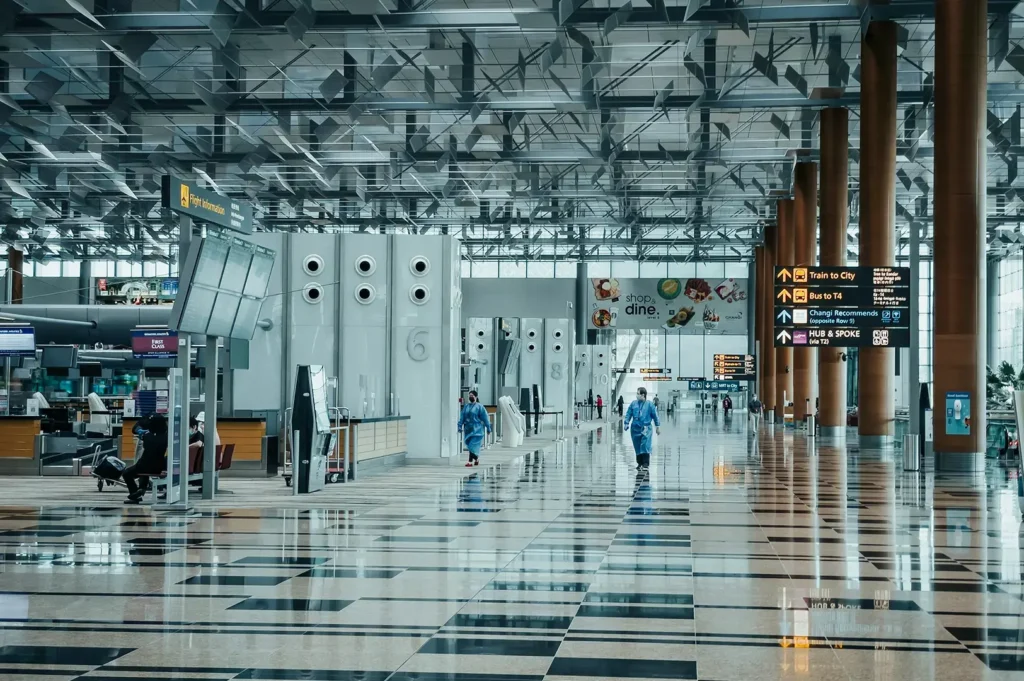 Changi Airport departure hall with reflective floor and signage.
