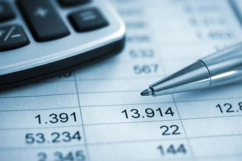 Calculator, pen, and financial spreadsheet