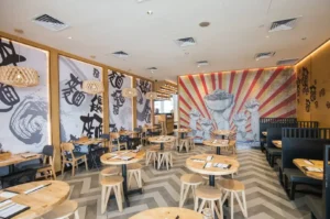 LeNu Chef Wai's Noodle Bar interior with tables and wall murals.