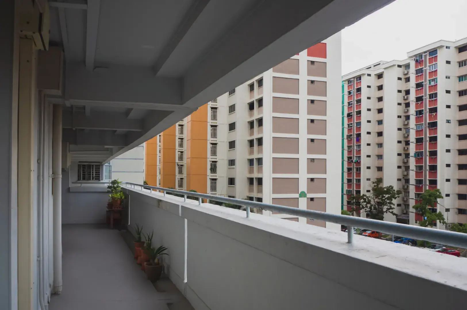 A view from a covered walkway looking out at several tall apartment buildings with balconies and windows.